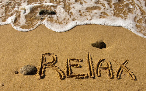 Relax written in sand