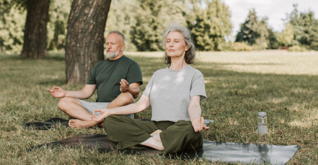 couple doing yoga in the park