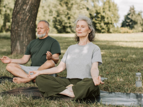 couple doing yoga in the park