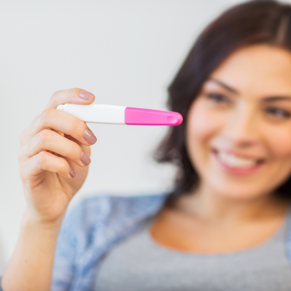 Woman smiling holding pregnancy test